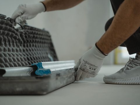 Fliesenleger arbeitet mit Werkzeug auf dem Fliesenboden