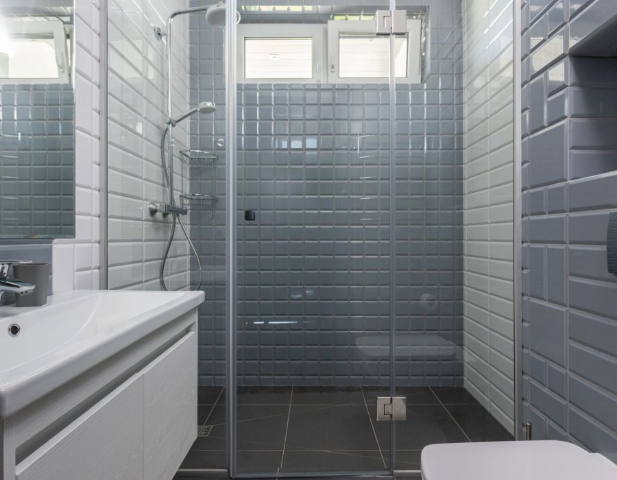 Bad mit grauen Metrofliesen und bodengleicher Dusche